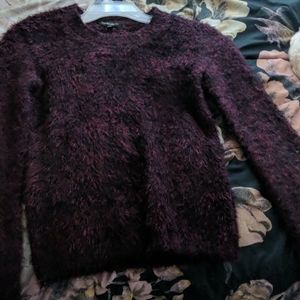 A fuzzy maroon sweater